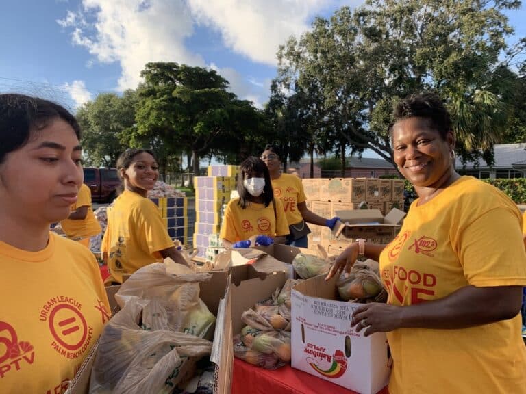 volunteers wearing yellow shirts holding boxes