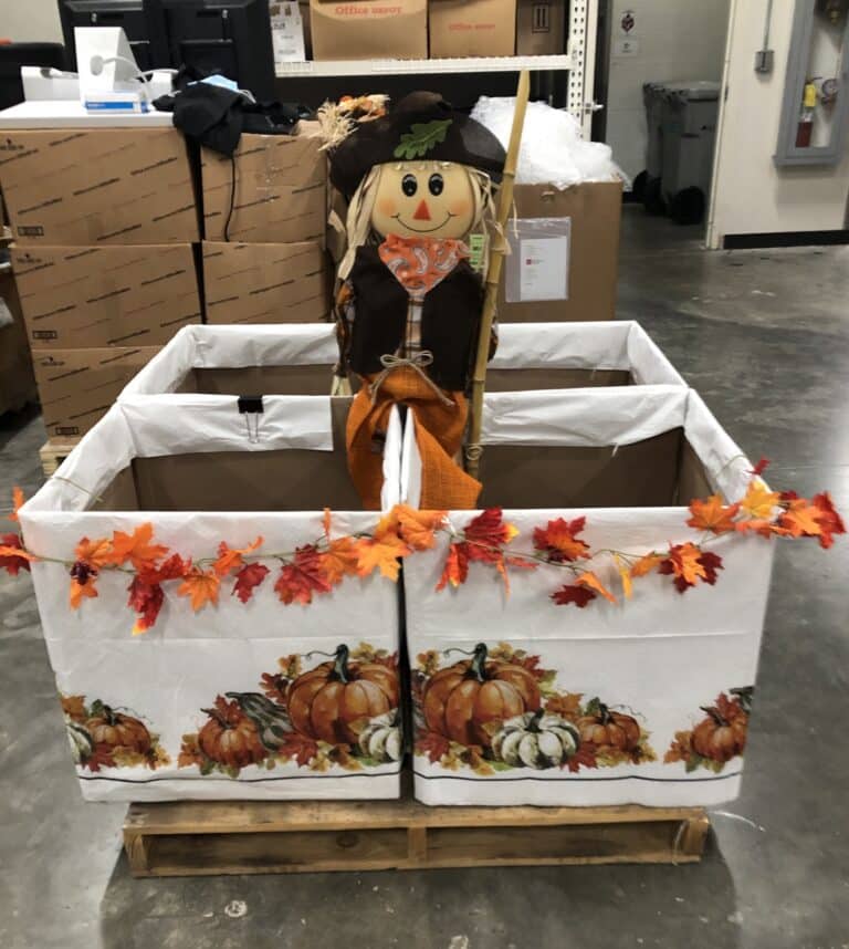 Scarecrow doll on top of boxes decorated for Fall